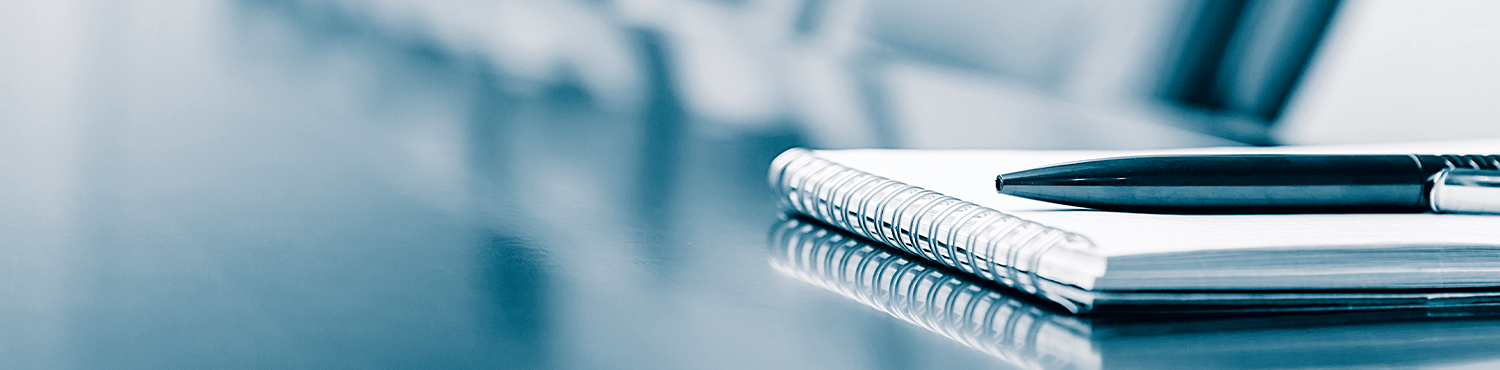 Background - blue, clear, a pen and a notebook on a table.